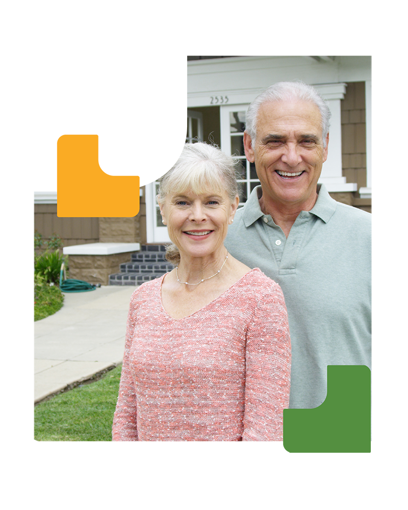 Elderly couple in front of their home